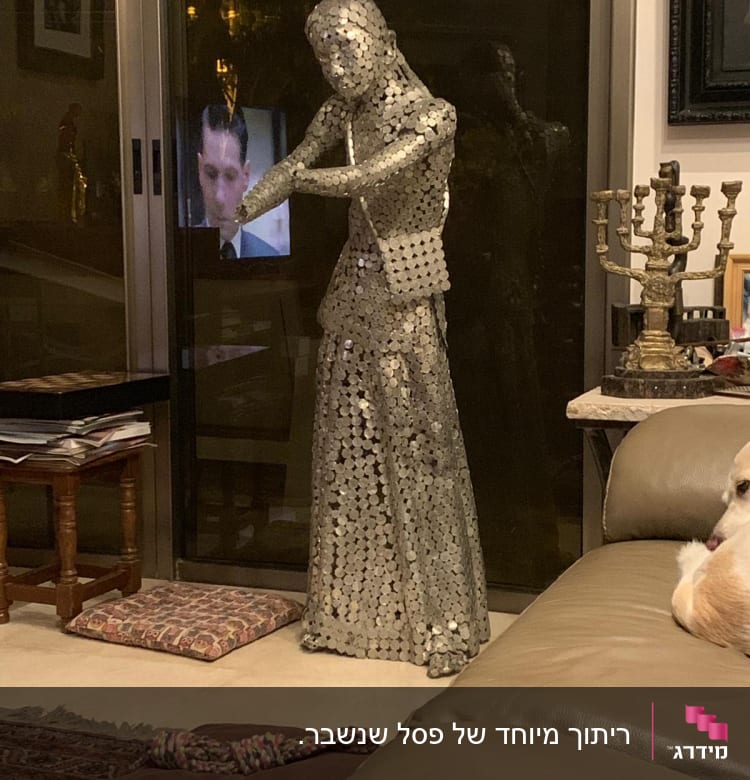 פסל מתכת עומד ליד חלון זכוכית